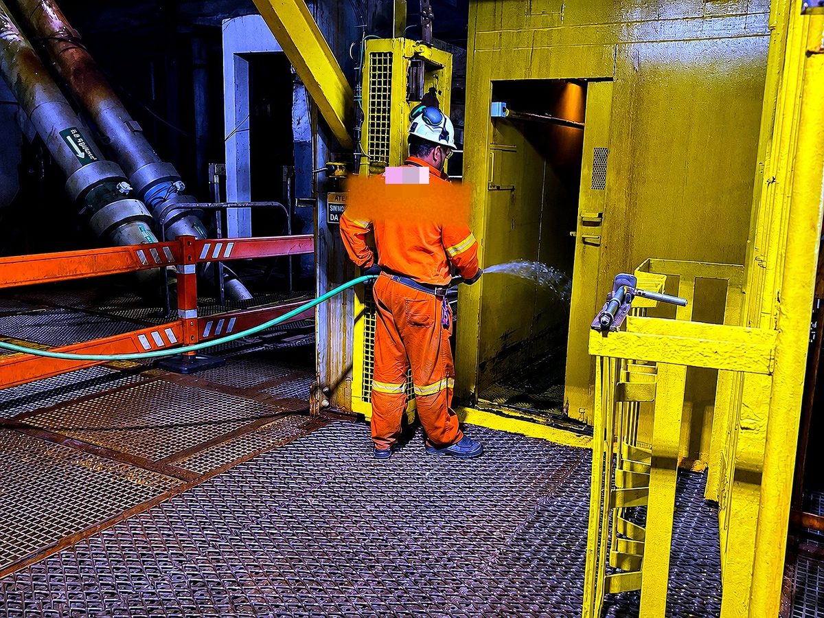 Equipe de apoio de superfície realizando a lavagem e manutenção do elevador da mina